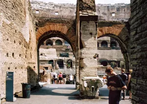 Visitors admire the historic Colosseum's architecture in Rome, with arches and ancient walls visible. jigsaw puzzle