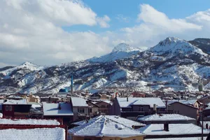 Scenic view of snow-covered Isparta town with majestic mountains, under a blue sky. jigsaw puzzle