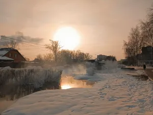Peaceful winter sunset scene in a Russian suburb with snow-covered landscape. jigsaw puzzle