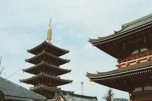 A stunning view of the iconic pagoda at Senso-ji Temple in Tokyo, Japan under a clear blue sky. jigsaw puzzle