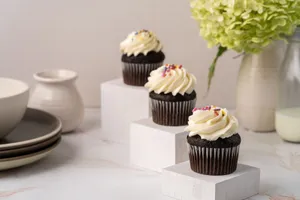 Three chocolate cupcakes with creamy frosting and sprinkles displayed elegantly with decor. jigsaw puzzle