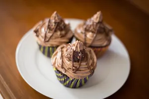 High angle selective focus of sweet chocolate cake decorated with cream served on white plate jigsaw puzzle