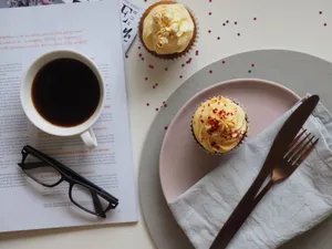 Cozy setup with cupcakes, coffee, and reading glasses, perfect for a relaxed afternoon. jigsaw puzzle