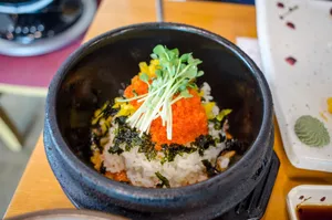 A delicious Asian rice bowl topped with fresh vegetables and roe, perfectly plated for a mouth-watering meal. jigsaw puzzle