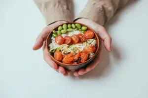 Close-up of hands holding a salmon poke bowl with cherry tomatoes, edamame, and rice. jigsaw puzzle