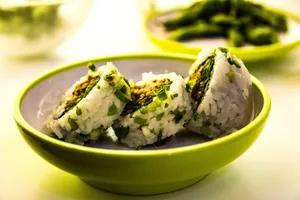 Close-up of sushi rolls garnished with green onions, served in a bowl. jigsaw puzzle