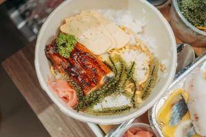 Close-up of a Japanese unagi rice bowl with seaweed, parsley, and tamagoyaki, perfect for food photography. jigsaw puzzle
