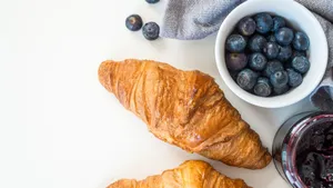 A tempting French breakfast featuring croissants, fresh blueberries, and jam, perfect for a healthy start. jigsaw puzzle
