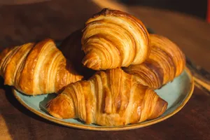 Close-up of freshly baked golden croissants on a plate, perfect for breakfast imagery. jigsaw puzzle