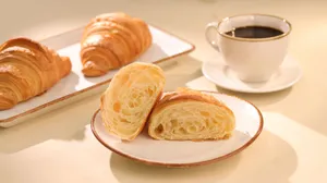 Freshly baked croissants served with a cup of black coffee, perfect for breakfast. jigsaw puzzle