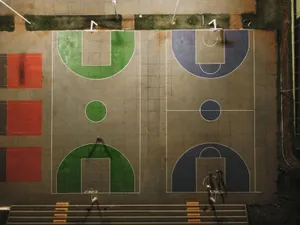 Top-down view of vibrant basketball courts at night in Brazil, showing detailed court markings. jigsaw puzzle