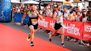 Two marathon runners sprint towards the finish line amid a cheering crowd during a race. jigsaw puzzle