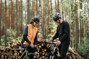 Two men with bicycles in forest, wearing helmets and sportswear, ready for outdoor cycling. jigsaw puzzle