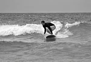 Dynamic black and white shot of a surfer riding waves in Brazil, capturing the movement and thrill of surfing. jigsaw puzzle