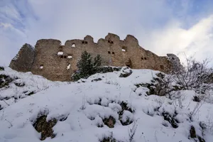 Majestic castle ruins covered in snow under a winter sky. jigsaw puzzle