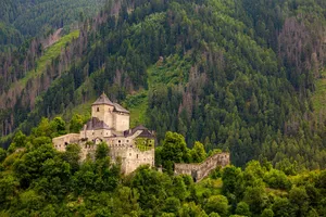 Taufers Castle nestled in the lush Austrian Alps, surrounded by dense green forests. jigsaw puzzle