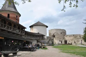 Explore a historic medieval castle courtyard with ancient towers and gathering visitors. jigsaw puzzle