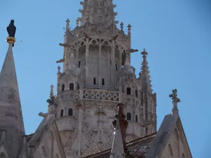 Close-up of intricate Gothic cathedral spire under a clear blue sky, showcasing architectural details. jigsaw puzzle