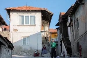 A vibrant street scene in Ankara featuring people relaxing outside traditional houses. jigsaw puzzle