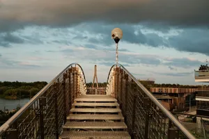 A picturesque view from a pedestrian bridge at sunset with dramatic clouds and urban architecture. jigsaw puzzle