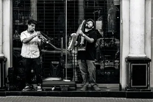 Two street musicians playing trumpet and saxophone in Buenos Aires, creating a lively urban scene. jigsaw puzzle