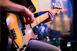 Detailed close-up of a musician playing a vintage bass guitar during a live performance. jigsaw puzzle