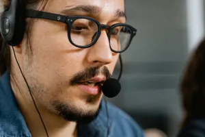 Close-up of a call center agent with a headset and eyeglasses providing customer support. jigsaw puzzle
