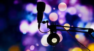 A studio microphone and headphones in silhouette against a vibrant bokeh background. jigsaw puzzle