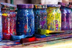 Vibrant mason jars splattered with paint alongside brushes in an Istanbul art studio. jigsaw puzzle
