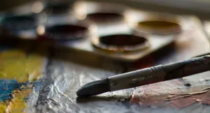 Artistic close-up of a paintbrush and palette capturing colorful creativity and texture. jigsaw puzzle