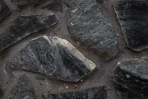 Detailed close-up of rugged stone texture with irregular shapes on a wall surface. jigsaw puzzle