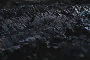 A detailed close-up of dark charcoal texture, showcasing its rough and jagged surface. jigsaw puzzle