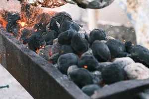 Sparks fly from burning charcoal on a barbecue grill, creating a hot and fiery atmosphere. jigsaw puzzle
