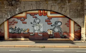 Colorful mural of cartoon mice with cheese on a wall under an arch in Germany. jigsaw puzzle
