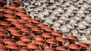Sunlit display of handcrafted terracotta and clay pottery drying outdoors in rows. jigsaw puzzle