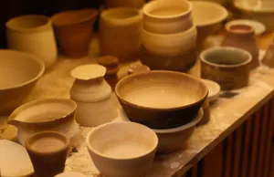 A collection of handcrafted ceramic bowls displayed in an artisan pottery studio with soft lighting. jigsaw puzzle