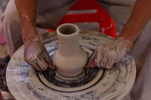 Close-up of hands crafting pottery vase on spinning wheel, showcasing artisanal skills. jigsaw puzzle