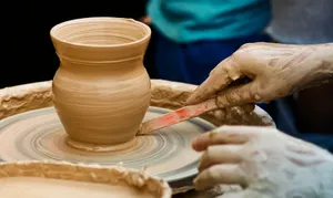 Close-up of hands shaping pottery on a wheel, focused on the artisan's skill and detail. jigsaw puzzle