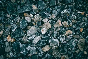 A detailed close-up of textured gravel featuring various stones and rocks outdoors. jigsaw puzzle