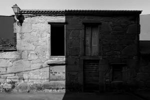 Black and white photo of an abandoned stone building facade with deep shadows. jigsaw puzzle