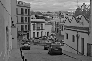 Explore a vintage city street with parked cars and classic architecture in black and white. jigsaw puzzle