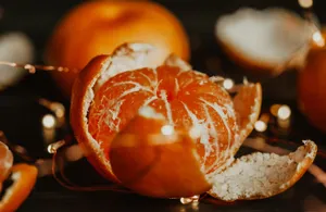 A peeled orange with bokeh lights in the background, creating a warm and festive atmosphere. jigsaw puzzle