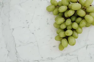 Cluster of fresh green grapes on a clean marble background, perfect for health and nutrition themes. jigsaw puzzle