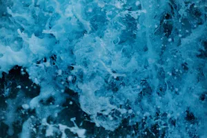 Dynamic close-up of vibrant blue waves crashing, capturing the essence of ocean power and movement. jigsaw puzzle